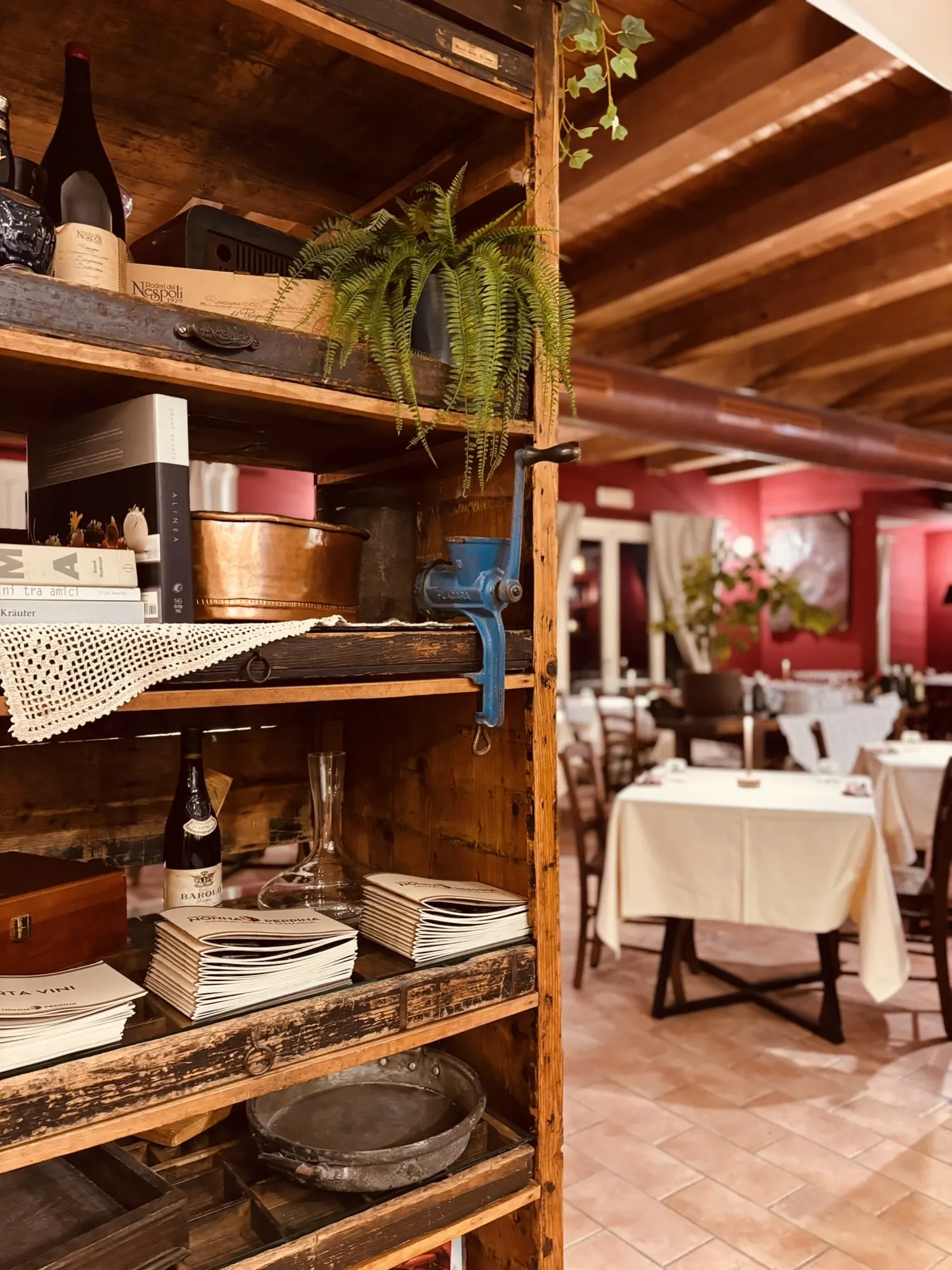 Dettaglio della sala di Nonna Peppìna Ravenna con scaffale in legno e oggetti d'arredo