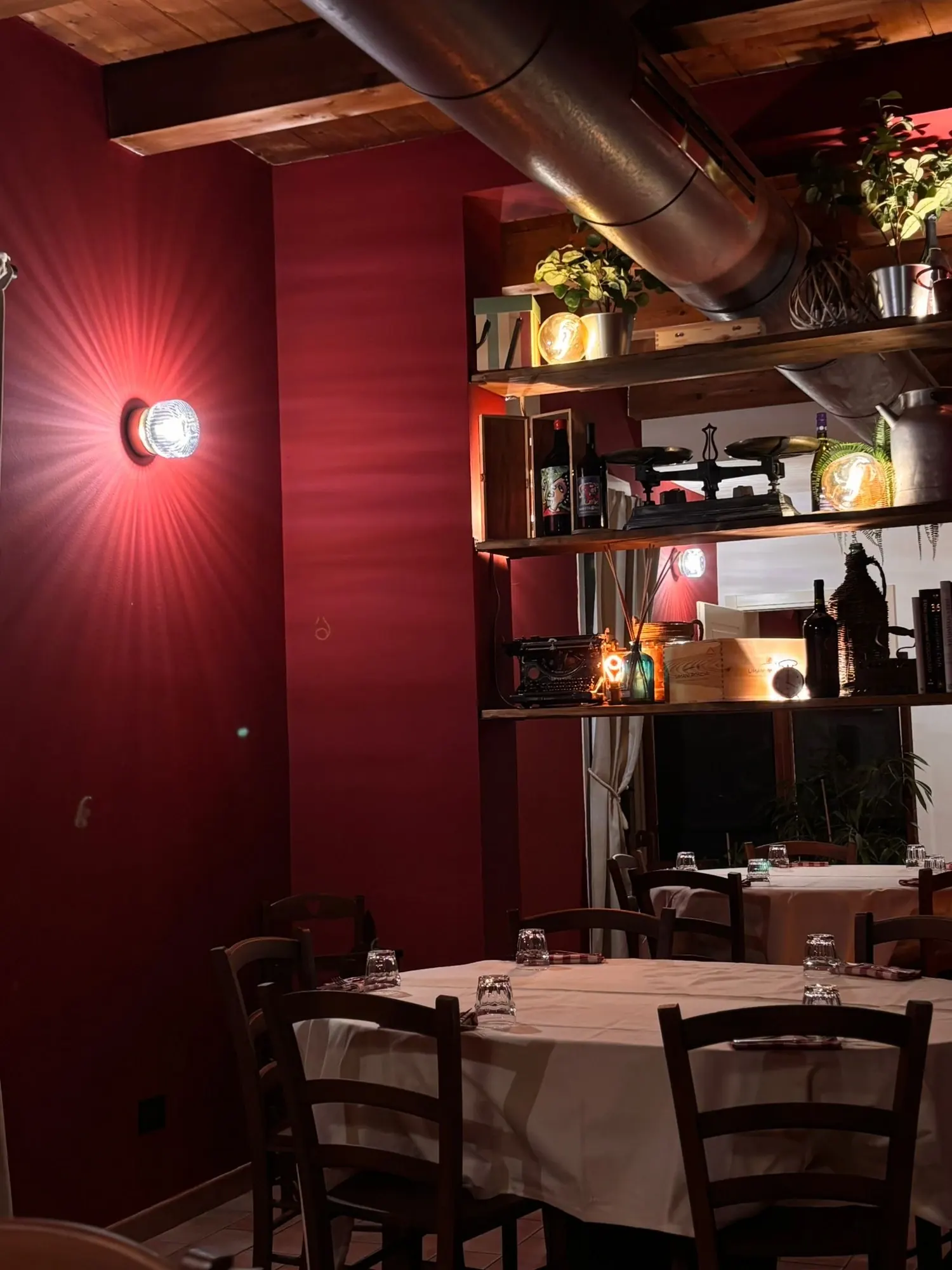 Sala di Nonna Peppìna Ravenna con tavoli apparecchiati e pareti rosse