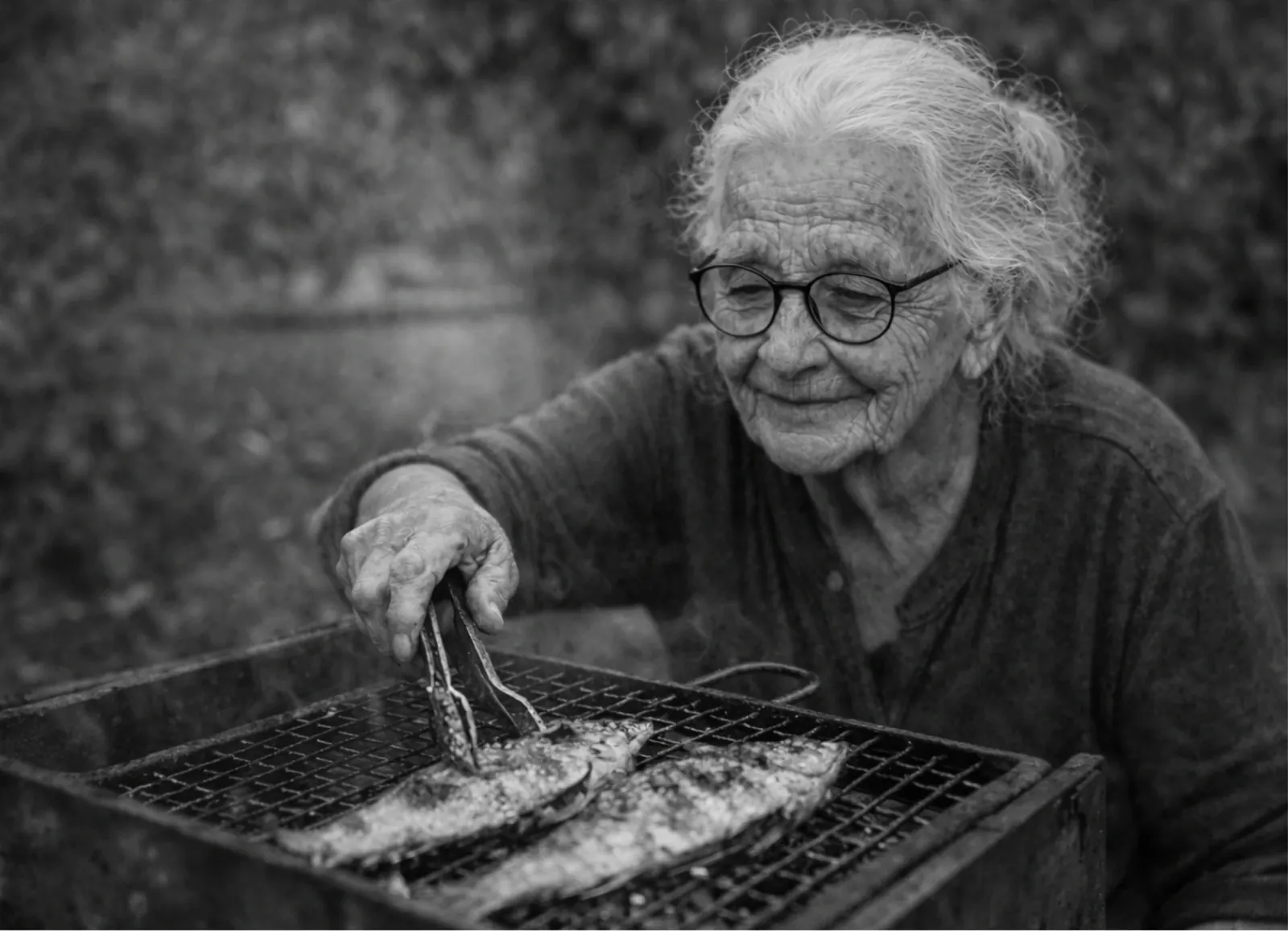 Nonna Peppìna cuoce il pesce sulla griglia all'aperto